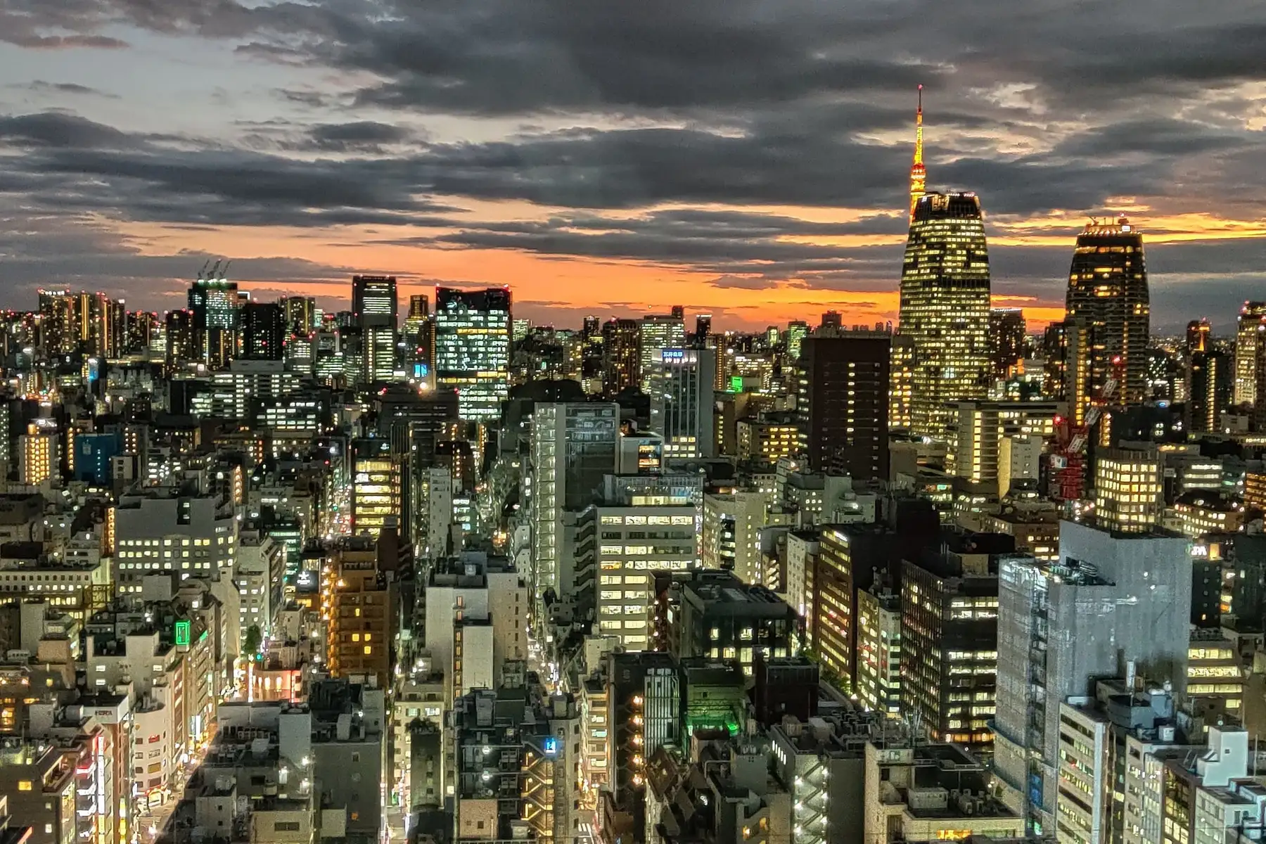 Neon and rail lines converging over a Tokyo street at night